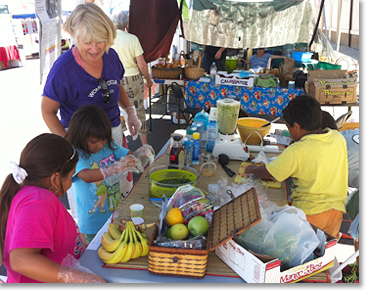 On another Sunday, WOSD member Anne Barron set up another booth and showed children how to make smoothies with fresh fruits and vegetables.