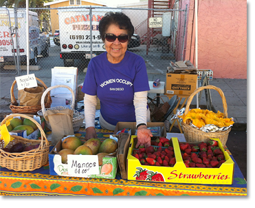 Virginia Franco showing off fresh fruits and squash blossoms (on the right) at the Women Occupy San Diego booth at Sobreruedas (30th and Imperial) n San Diego..Photos by Nic Paget-Clarke.
