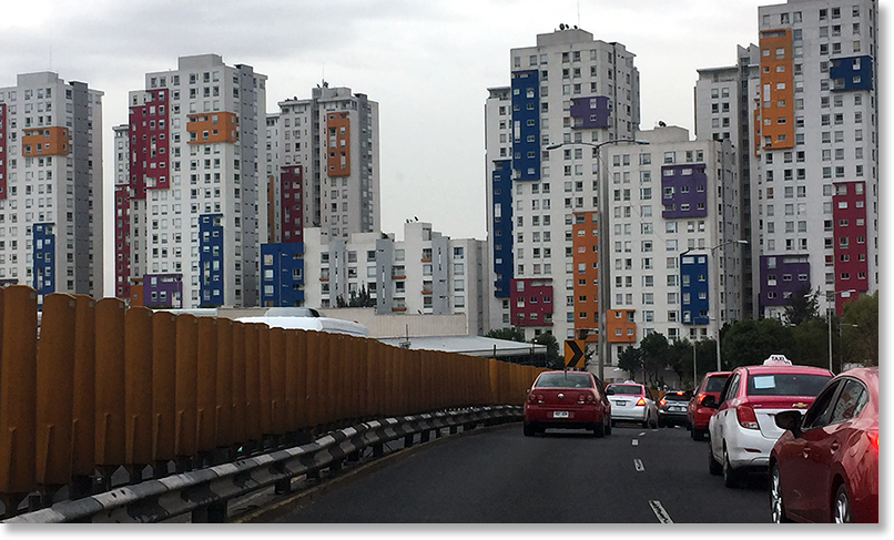 Traffic and colorful housing apartment buildings in Mexico City.