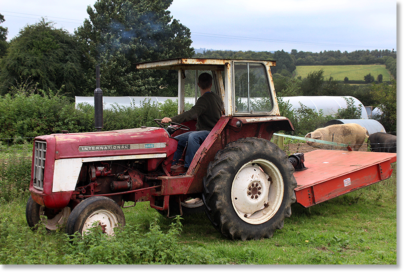 Adam Payne maneuvers the tractor before putting it into the barn out of the weather. West Dorset, England.