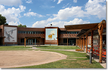  A circle of large murals surrounds the central meeting area within the Indian Pueblo Cultural Center ("Gateway to the 19 Pueblos of New Mexico.") in Albuquerque. Mural on the left "The Eagle Dance" by J.D. Medina  © 1978. Mural on the right: "Horses" © 1978 by Ow-u-Te-wa Juan Manuel "Bob" Chavez. Photo by Nic Paget-Clarke.