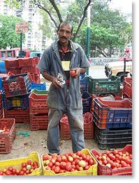 A farmer sells his produce at a community market in Caracas