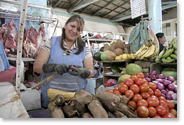 Vendiendo vegetales y frutas en el mercado de Cuenca.