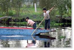Children pass by in another boat.