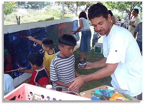 Artist Jose Ramirez encouraging children to paint at an event at the Los Angeles County Museum of Art. Photo by Nic Paget-Clarke.