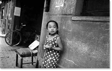 Girl outside house. Shanghai, China. Photo by Leon Sun.