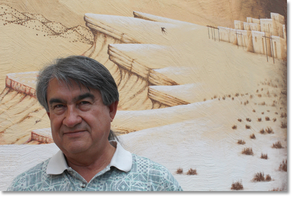 Dr. Gregory Cajete at the All Indian Pueblo Cultural Center in Albuquerque, New Mexico in front of a section of a mural by D.C. Arquero © '98. Photo by Nic Paget-Clarke.