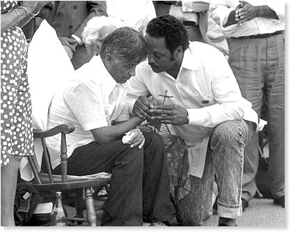 Cesar Chavez passes a cross symbolizing the Fast for Life to the Reverend Jesse Jackson - August 21, 1988.