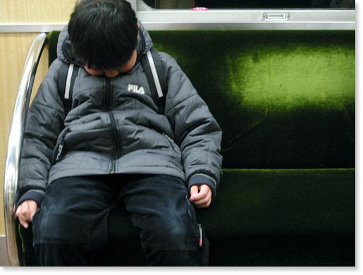 Sleeping boy in a train, Kobe, Japan. Photo by Otake Rie. 