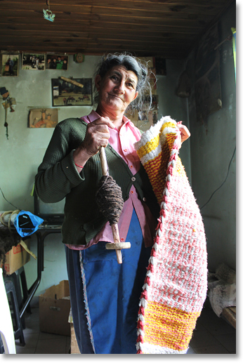 Pascuala Espinosa shares a look at her yarn spindle with yarn made from local animals and a textile she wove on her own loom. Villa del Curi Leuvú, Neuquen Province, Argentina. Photo by Nic Paget-Clarke.