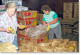 Preparing bags of food for distribution at one of the food coop distribution sites.